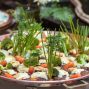 An artistic presentation of vegetables including broccoli, carrots, and greens on a copper platter.